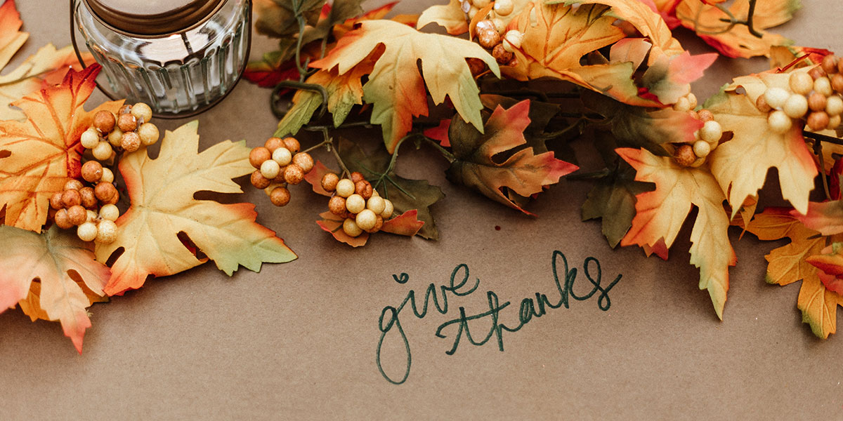 autumn table with give thanks handwritten on brown paper table covering